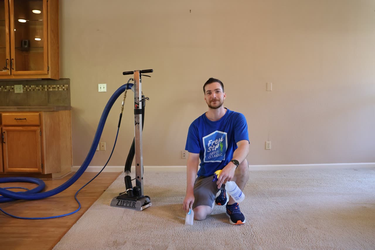 Fresh Step owner kneeling beside a carpet cleaning wand